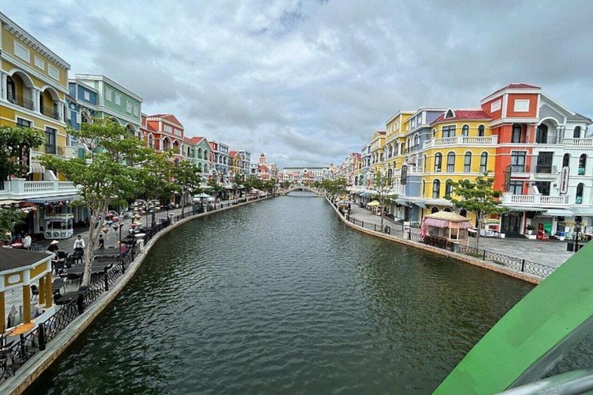 A canal lined with colorful buildings, a bridge, and a calm waterway. 2