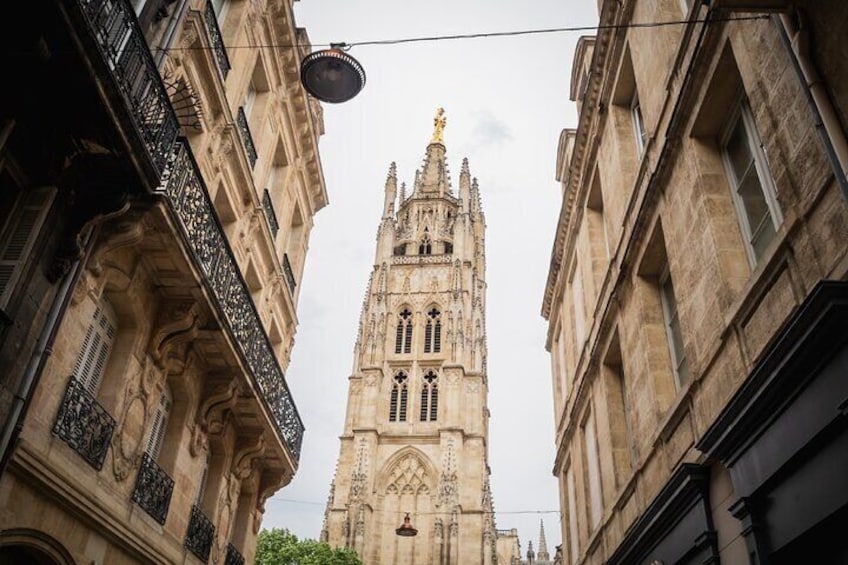 A tall, ornate cathedral with intricate architectural details and a statue on top. 3