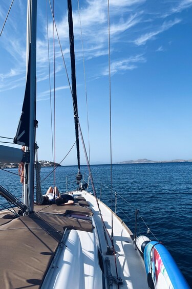 A sailboat with a clear blue sky and calm sea. 1