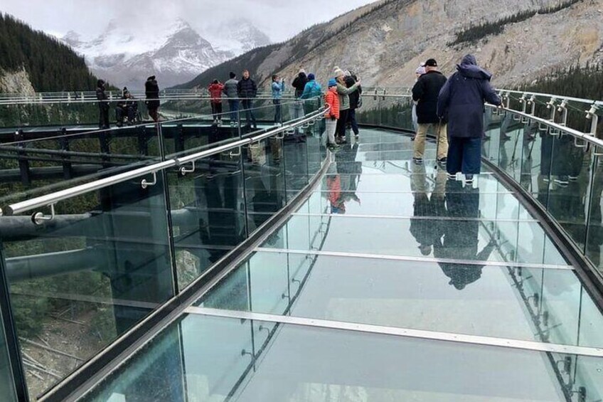 Un puente de cristal con gente caminando sobre él. 1