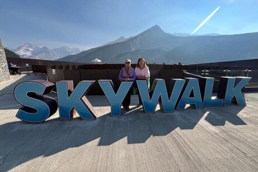 Las palabras SKY WALK en letras grandes con un paisaje montañoso. 3