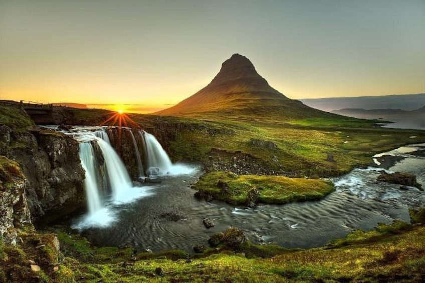 A waterfall, a river, and a mountain at sunset. 1