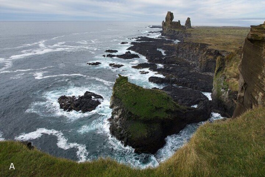 A coastal landscape with rocky cliffs and waves crashing against them. 4
