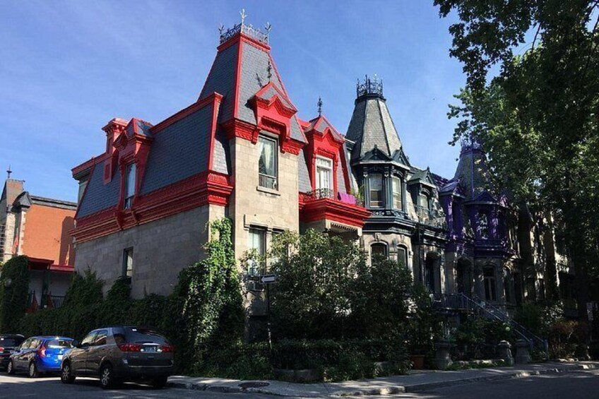 A Victorian-style house with red trim and a turreted roof. 2