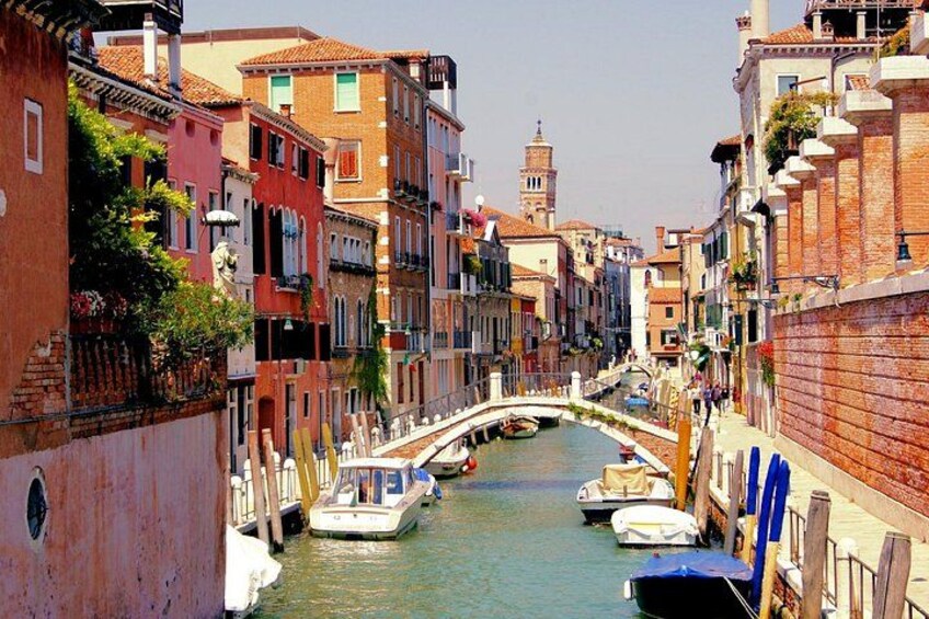 Un canal con barcos, un puente y edificios coloridos a orillas del agua. 2