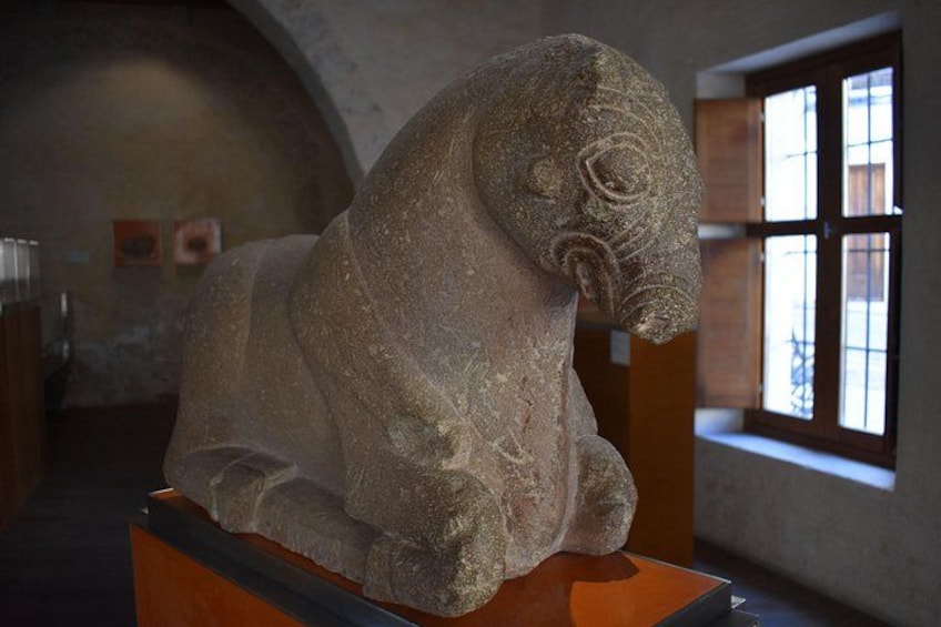 A stone sculpture of a lion in a museum. 5