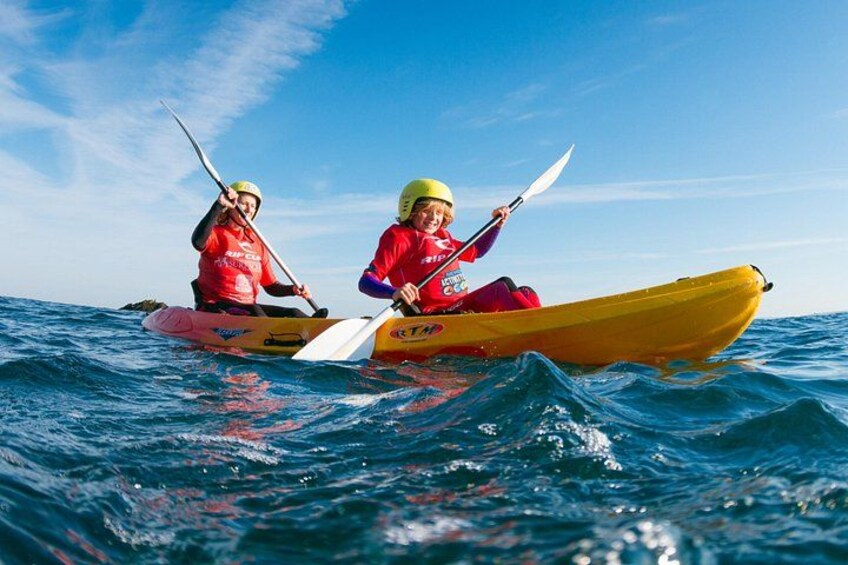 Two people kayaking on a body of water. 1