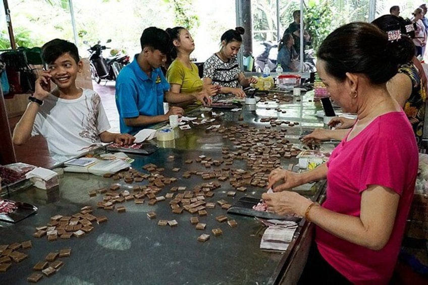 People at a food stall preparing and serving food. 4