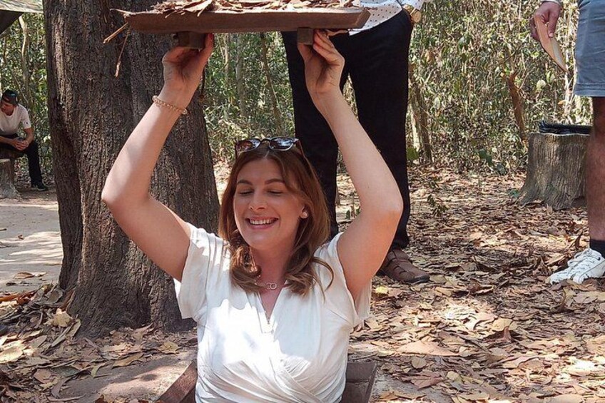 A person holding a tray above their head in a wooded area. 2