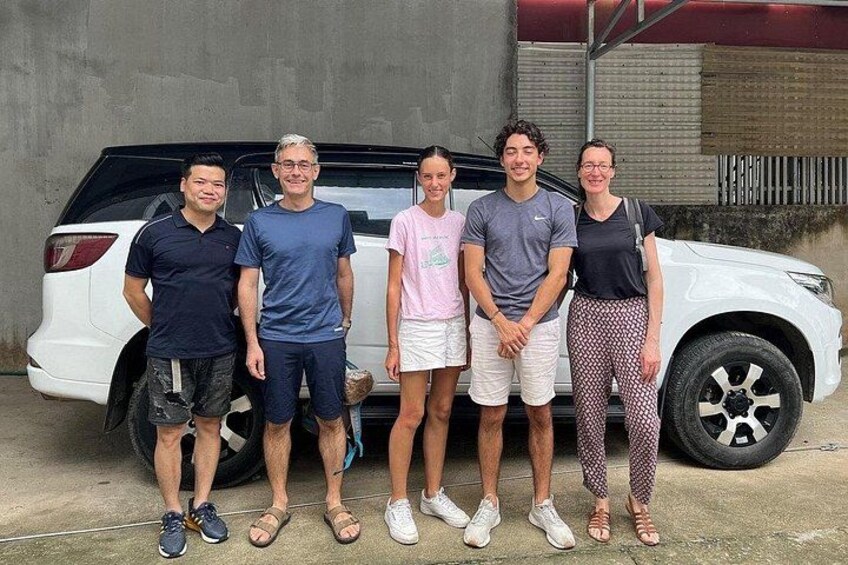 Five people standing in front of a white SUV. 1
