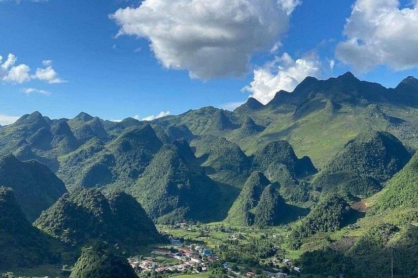 A mountainous landscape with a valley and a small settlement. 2