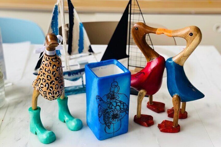 Wooden sculptures of animals and a sailboat on a table. 2