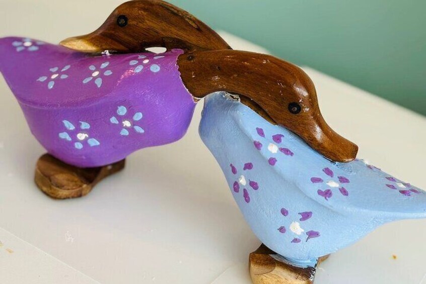 Two wooden bird figurines with painted wings. 5