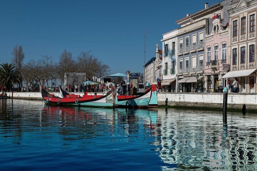 Dos barcos amarrados en una orilla con edificios al fondo. 4