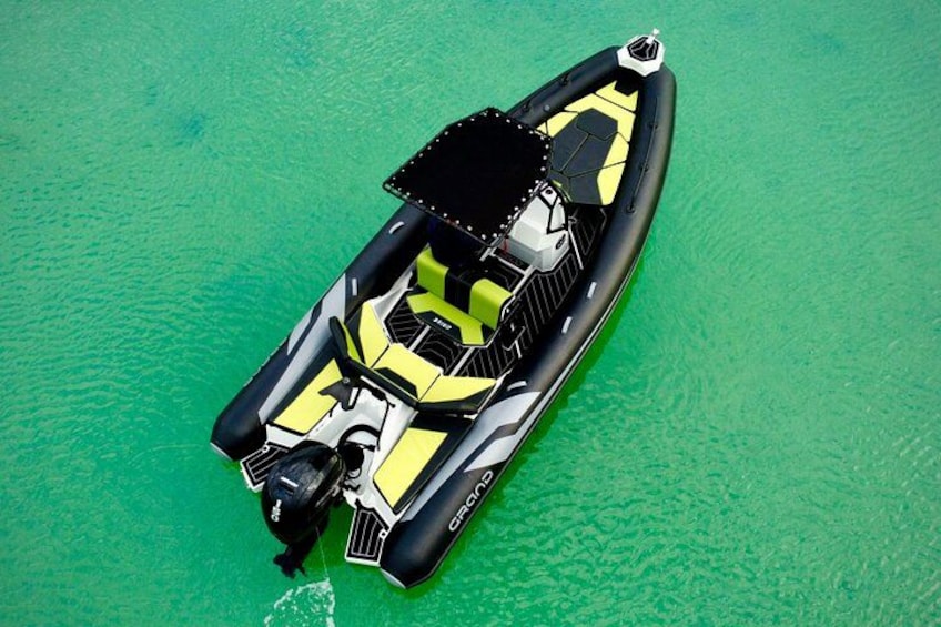 A small, yellow and black inflatable boat on a green surface. 2
