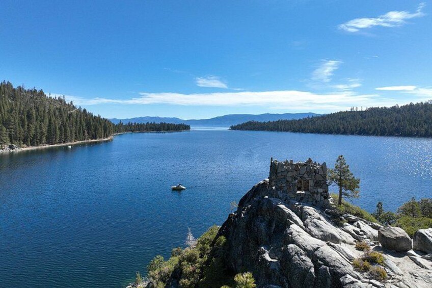Un lago con una pequeña embarcación, afloramientos rocosos e islas cubiertas de densa vegetación. 5