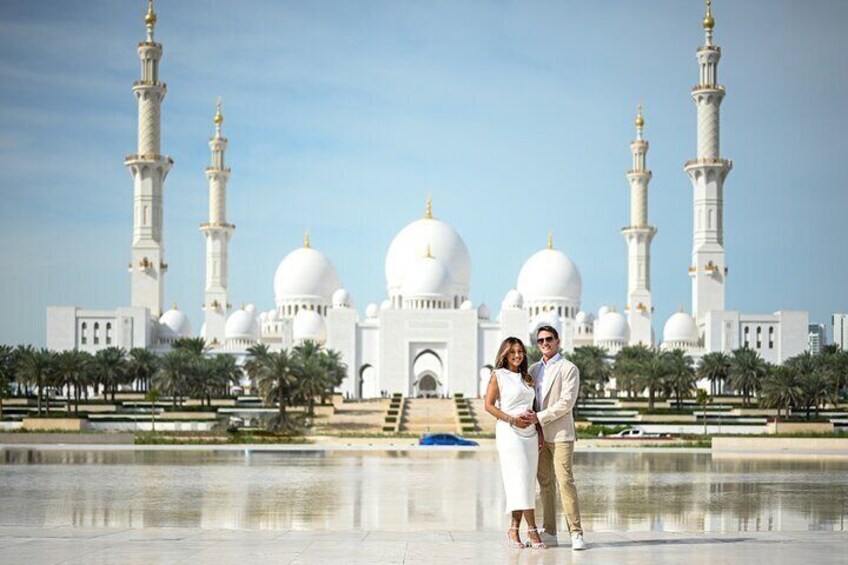 Una pareja está de pie frente a una gran mezquita blanca con varias cúpulas y minaretes. 4
