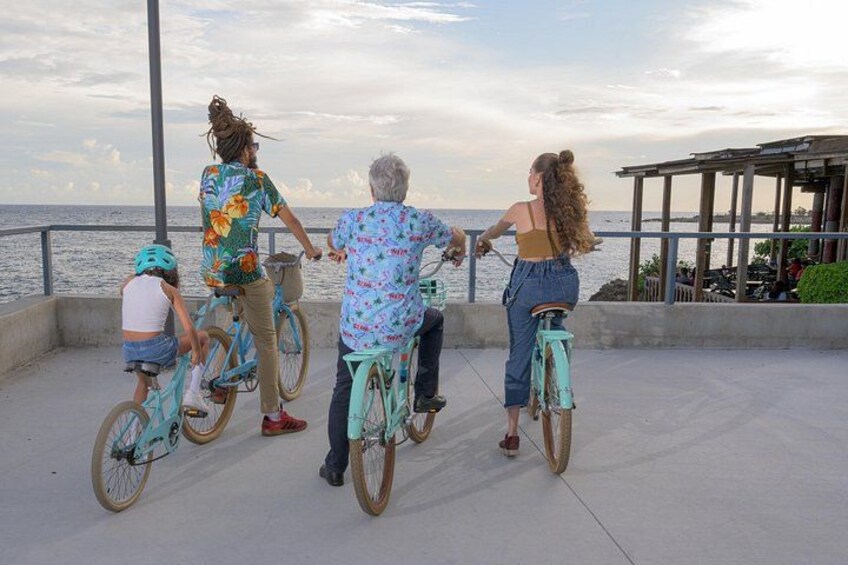 Un groupe de personnes fait du vélo sur une piste en béton au bord de la mer. 3