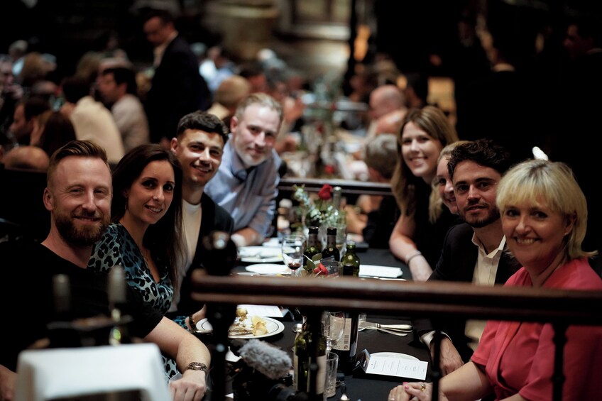 A group of people seated at a long table in a restaurant. 2