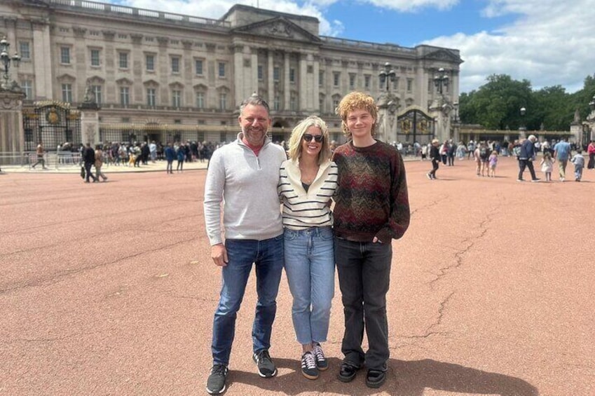 Three people standing in front of Buckingham Palace. 1