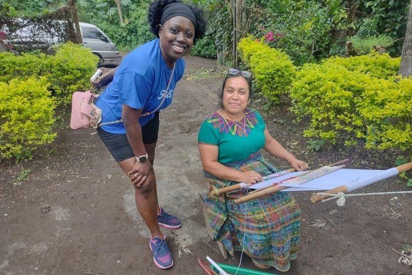Dos personas, una de pie y otra sentada, en un jardín con follaje y una hamaca. 5