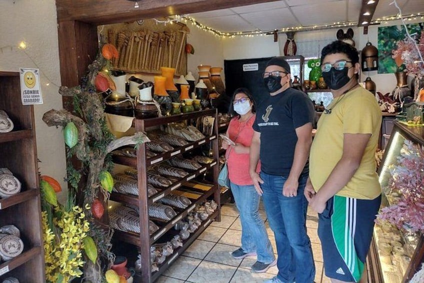 Una tienda con estantes llenos de cerámica y adornos, un letrero con un aviso, y un adorno navideño. 4