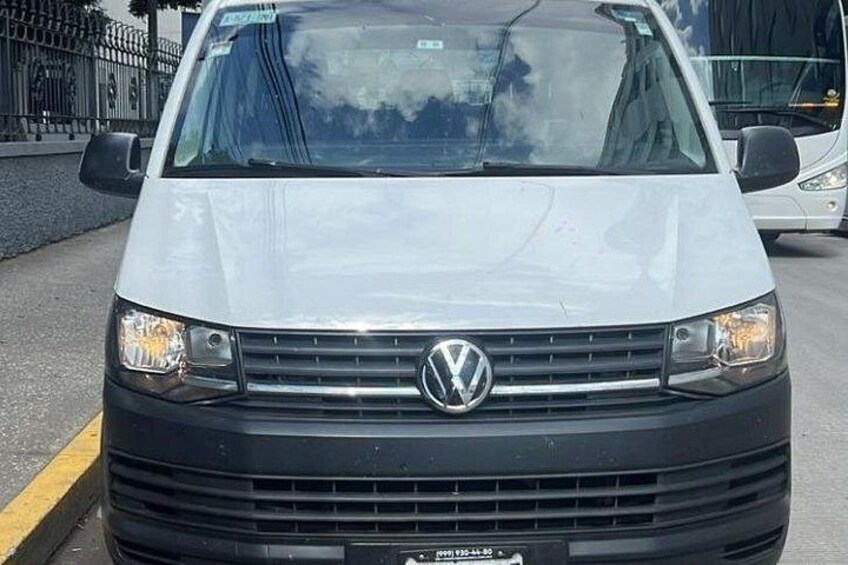 A white Volkswagen van parked on a street. 2