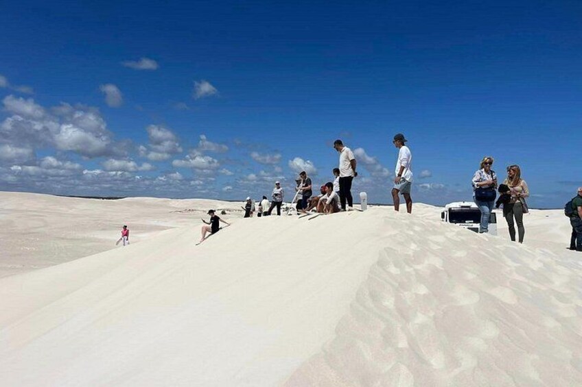 A group of people on a sandy landscape with a clear sky. 3