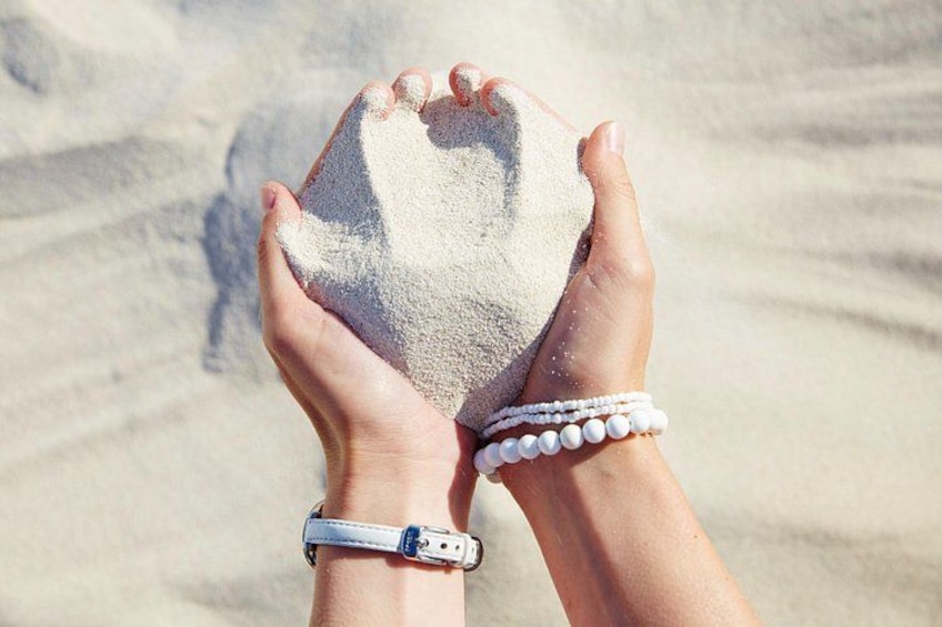 Hands holding a sandcastle on a beach. 2