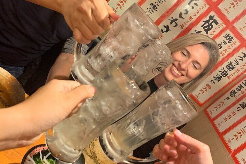 A person pouring a drink from a large bottle into a glass. 1