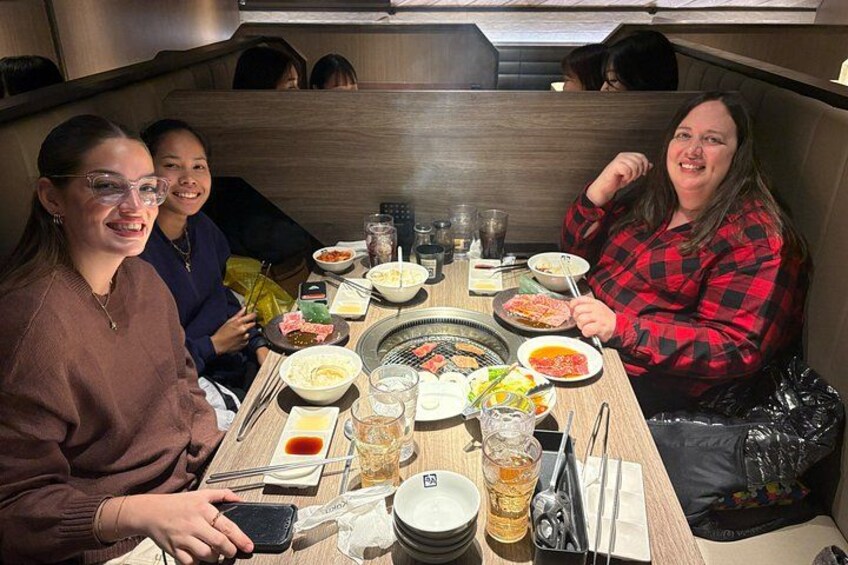 Un grupo de personas cenando en un restaurante con diversos platos y bebidas sobre la mesa. 4