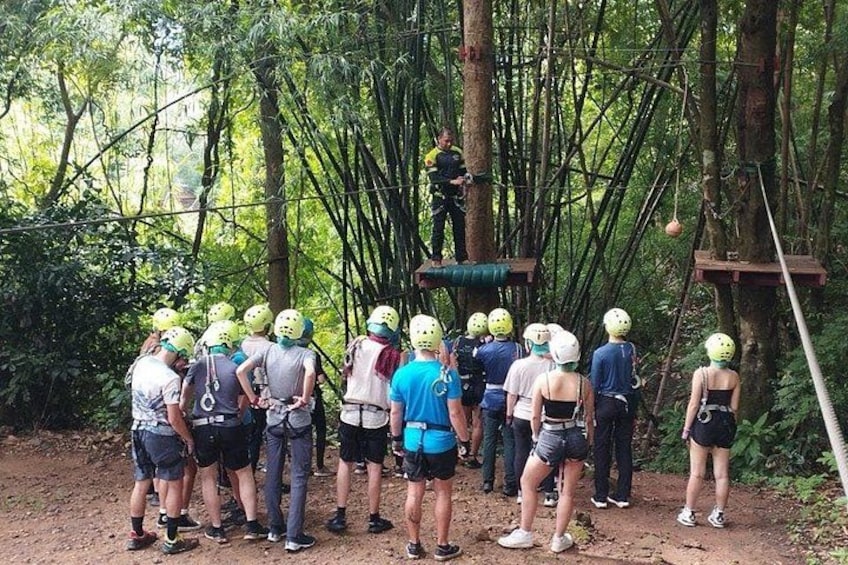 A group of people in helmets standing on a dirt path in a forest. 4