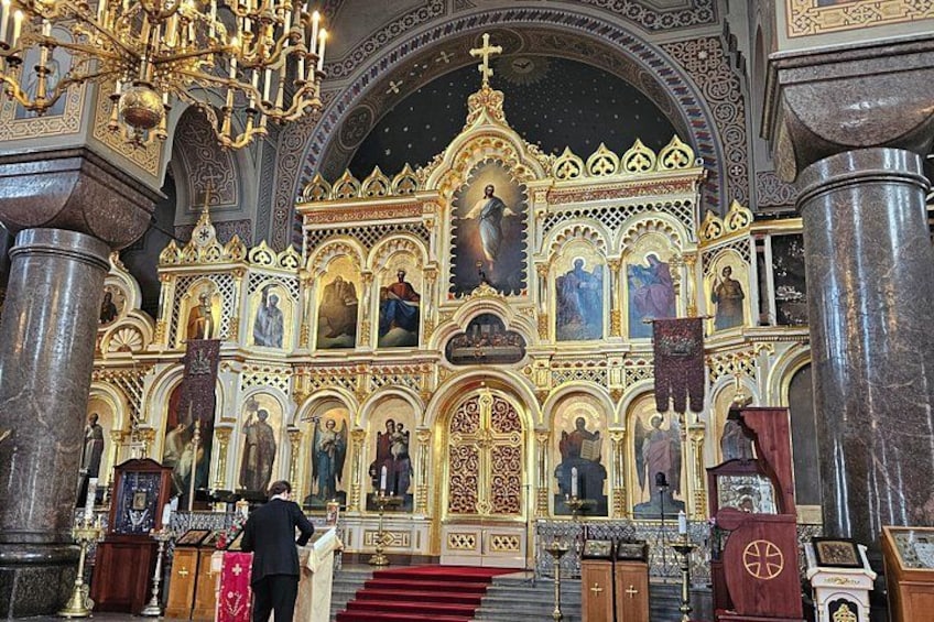 An ornate church interior with golden decorations, a large cross, and religious statues. 5