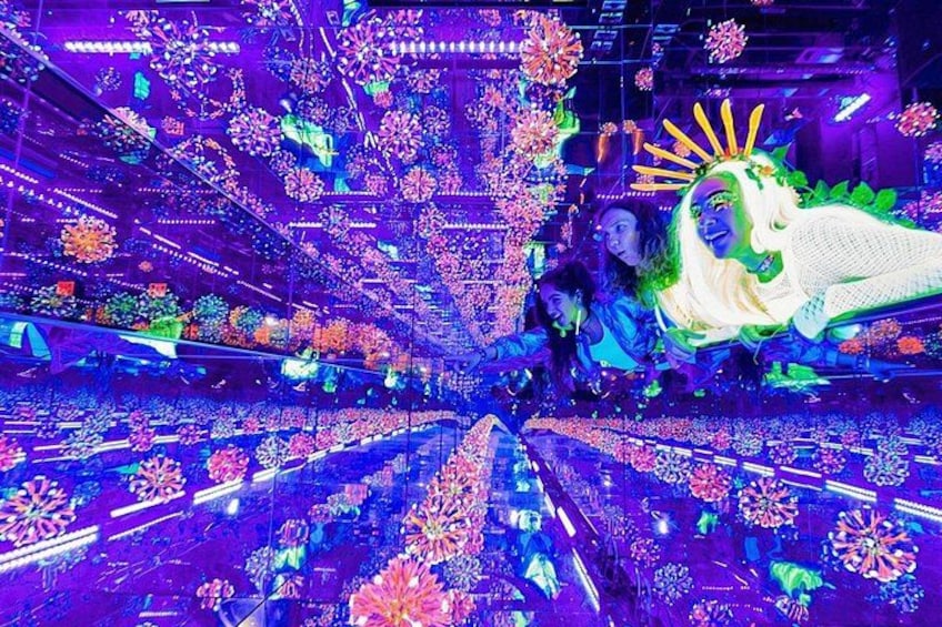 Un espace intérieur dynamique, doté d’un sol central réfléchissant, entouré de décorations florales colorées et illuminées. 2