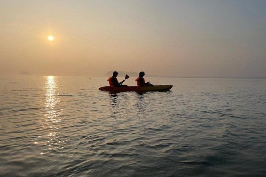 Dos personas en un bote pequeño sobre aguas tranquilas durante el amanecer. 2