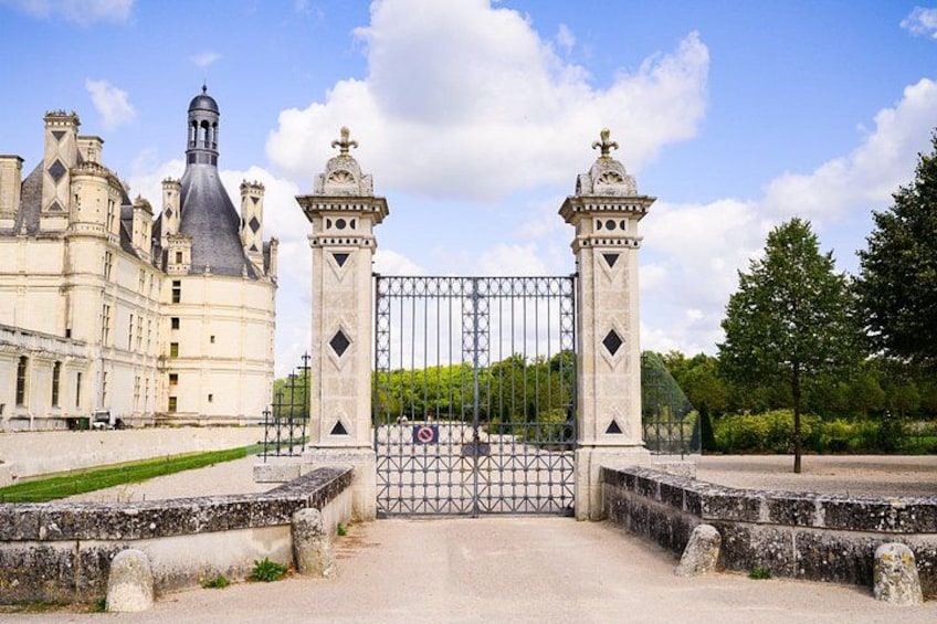 A historic building with a large gate, a tower, and a clear sky. 3