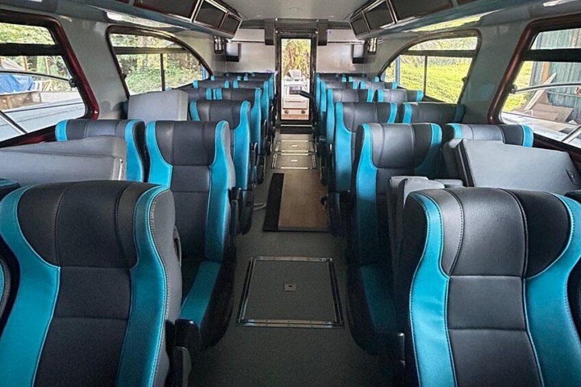 A train interior with rows of blue and black seats. 1