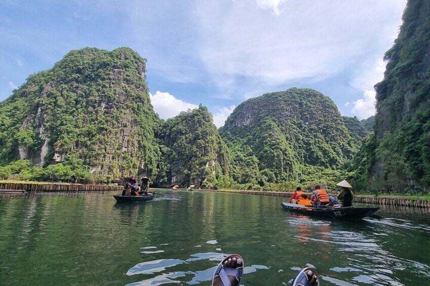 Un río con barcos, rodeado de exuberantes montañas verdes. 3