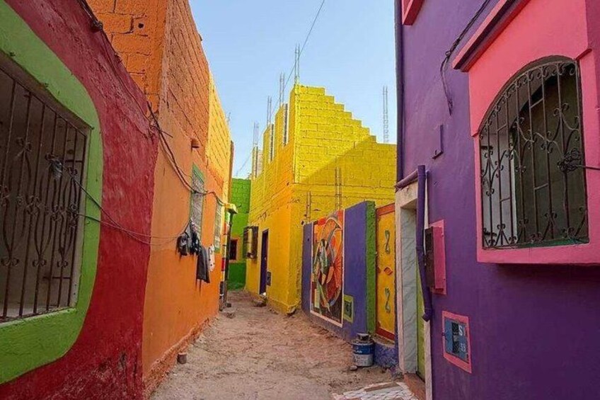 A narrow alley with colorful buildings painted in bright colors like yellow, green, and purple. 5