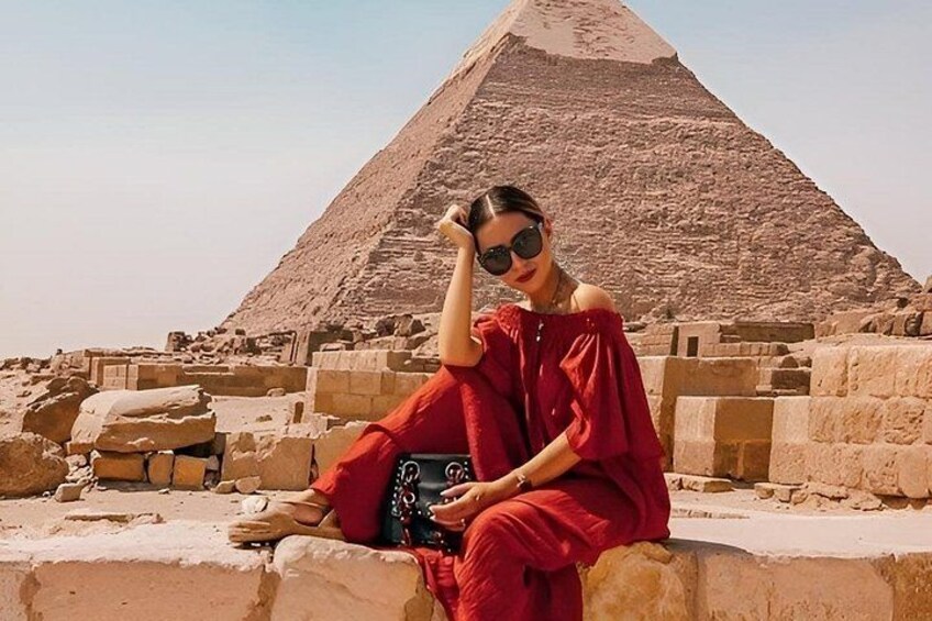 A person sitting in front of the Great Pyramid of Giza. 2