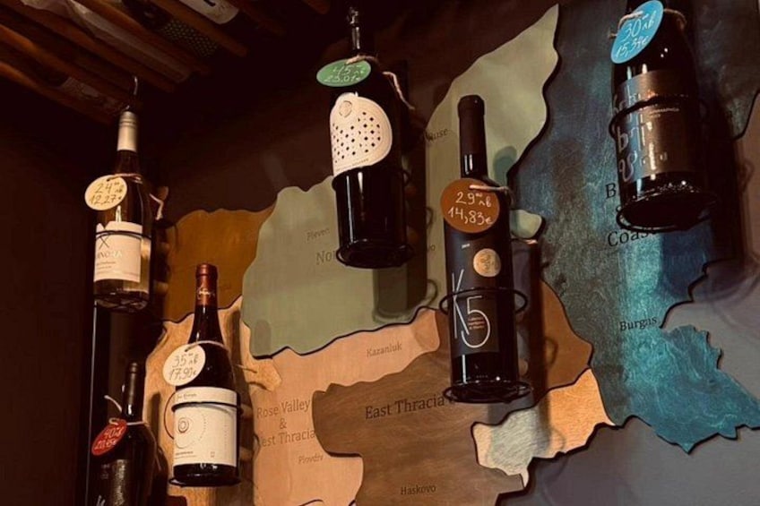 Bottiglie di vino su una mappa con etichette che indicano diverse regioni. 1