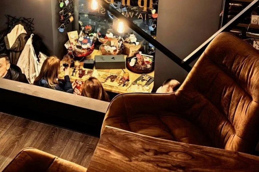 Interno di un ristorante con pavimento in legno, una poltrona in pelle marrone e un poster che mostra prodotti alimentari. 3