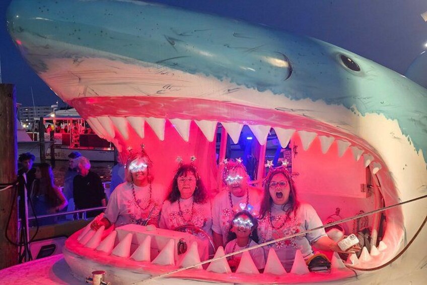 Una exhibición de tiburones con un gran modelo de tiburón y visitantes. 3
