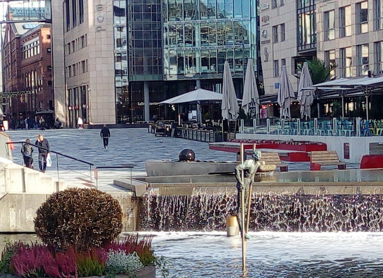 Kaupunginaukio, jossa on suihkulähde, moderneja rakennuksia ja ulkona sijaitsevia oleskelualueita. 4