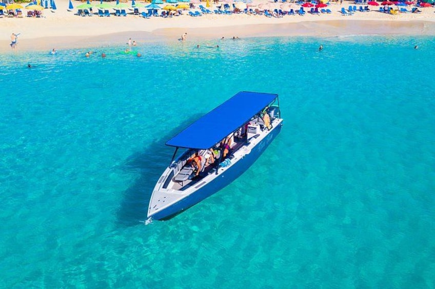 Un bote sobre aguas turquesas cristalinas con una playa al fondo. 3