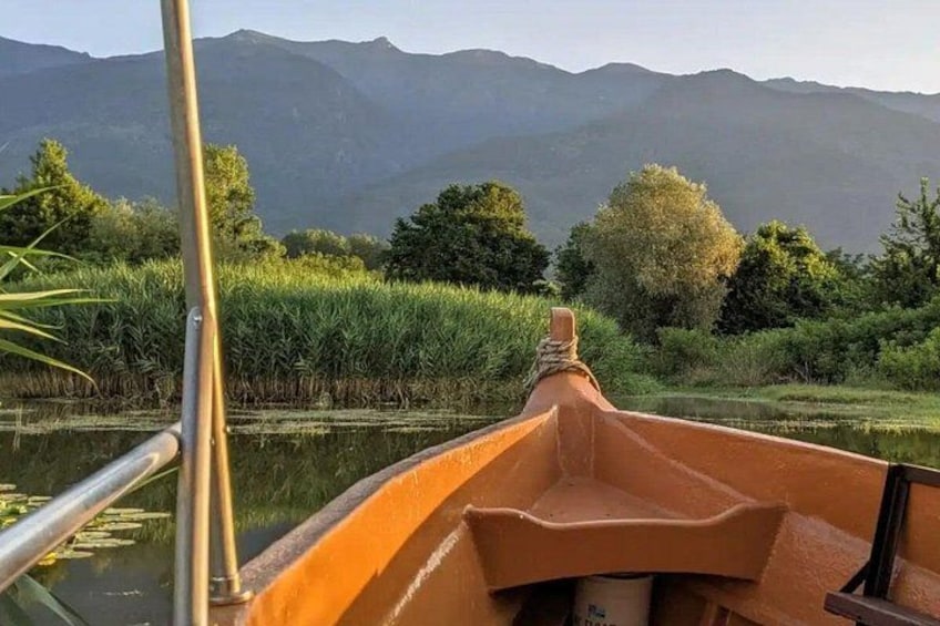 Un bote en un río tranquilo con un paisaje montañoso al fondo. 1