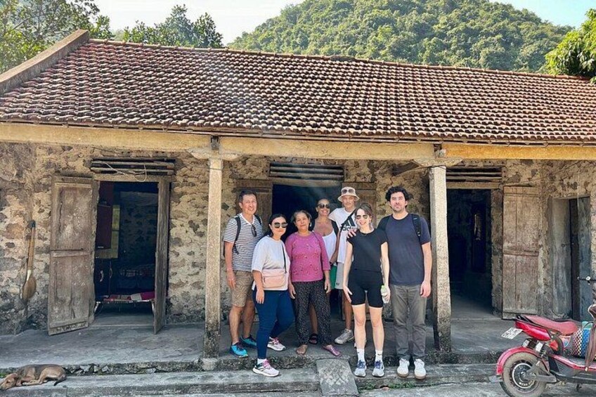 Un gruppo di persone in piedi di fronte a un edificio rustico con tetto in tegole e pareti in pietra. 3
