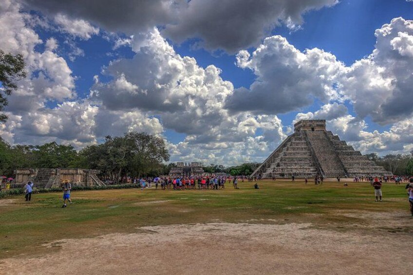 A large pyramid with tourists around it. 4