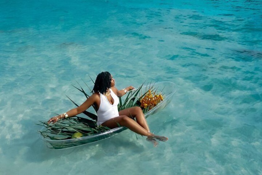 A person sitting on a boat in clear blue water. 4