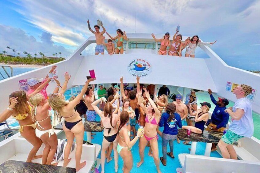 A group of people on a boat with a logo that reads 'TRAVELING THE WORLD' and a tropical landscape in the background. 1